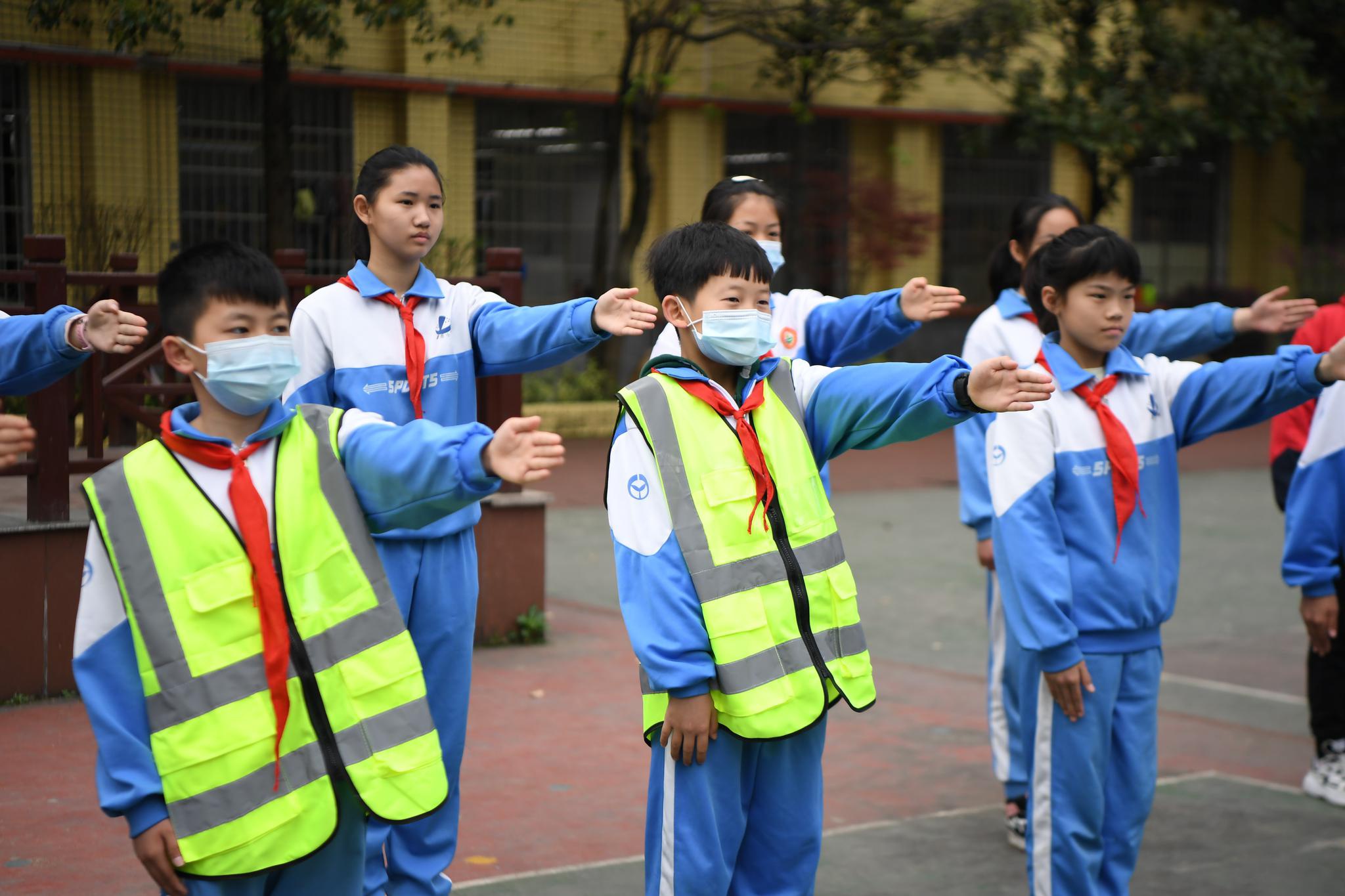 3月26日,长沙市望岳小学学生在操场学习交警手势.