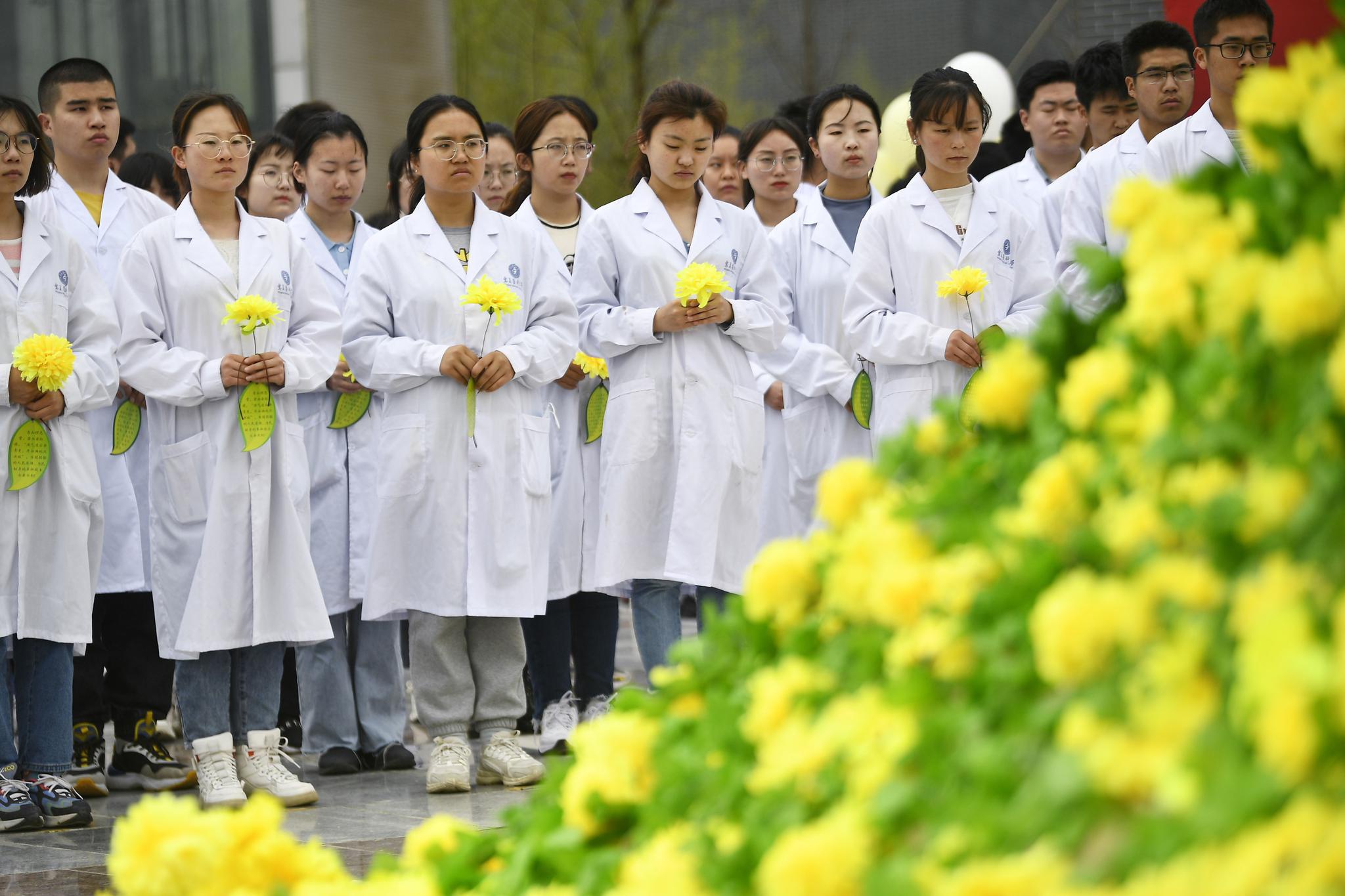 4月2日,宁夏医科大学学生在"生命之柱"前默哀(无人机照片).