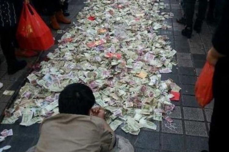 车上放着一只麻袋,让人想不到的是这位乞讨者把一麻袋的钱全部撒在