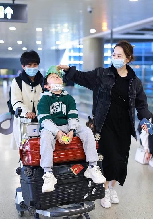 邓莎罕见带儿子走机场,肚腩臃肿疑有孕?8岁大麟子长成妈妈翻版