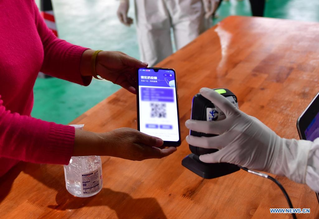 A medical worker scans QR code on the mobile phone screen for registration before a resident receives nucleic acid testing for COVID-19 at Munao community, Ruili City, southwest China's Yunnan Province, April 6, 2021. Ruili City in southwest China's Yunnan Province on Tuesday launched the second round of nucleic acid testing that includes all residents of the city proper. (Xinhua/Chen Xinbo)