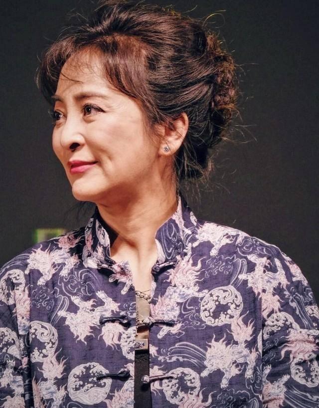 57岁李勤勤素颜现身街头拿大盆挡雨接地气同行男子身份引热议