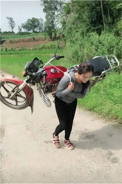 在小编认为,这位女子没有必要自己扛着摩托车回家,她可以选择推着走