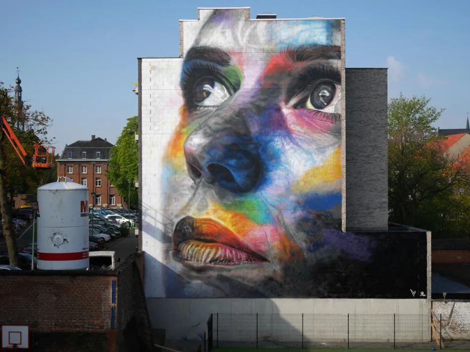 他拿着一罐喷漆直接在墙上绘画爆炸的肖像涂鸦引人注目