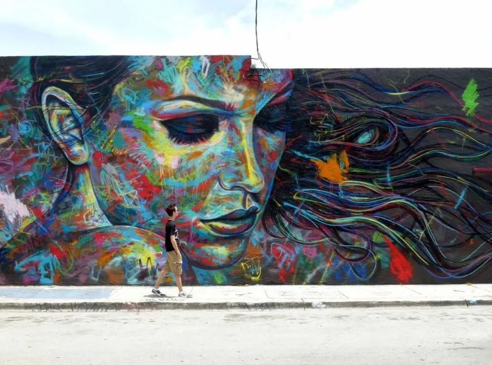 他拿着一罐喷漆直接在墙上绘画爆炸的肖像涂鸦引人注目