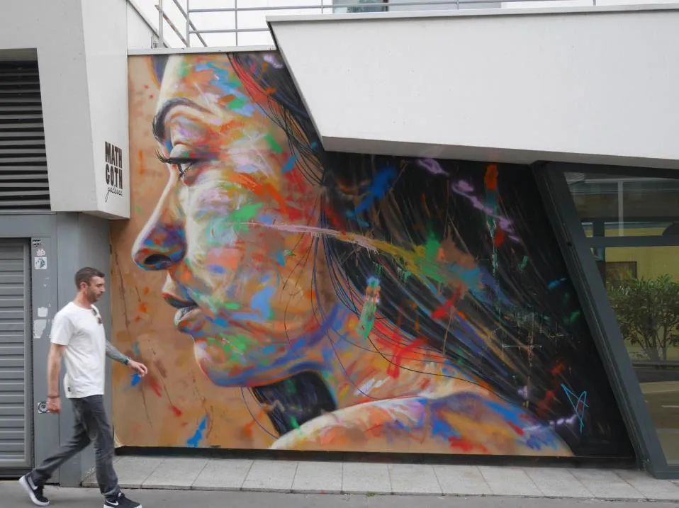 他拿着一罐喷漆直接在墙上绘画爆炸的肖像涂鸦引人注目