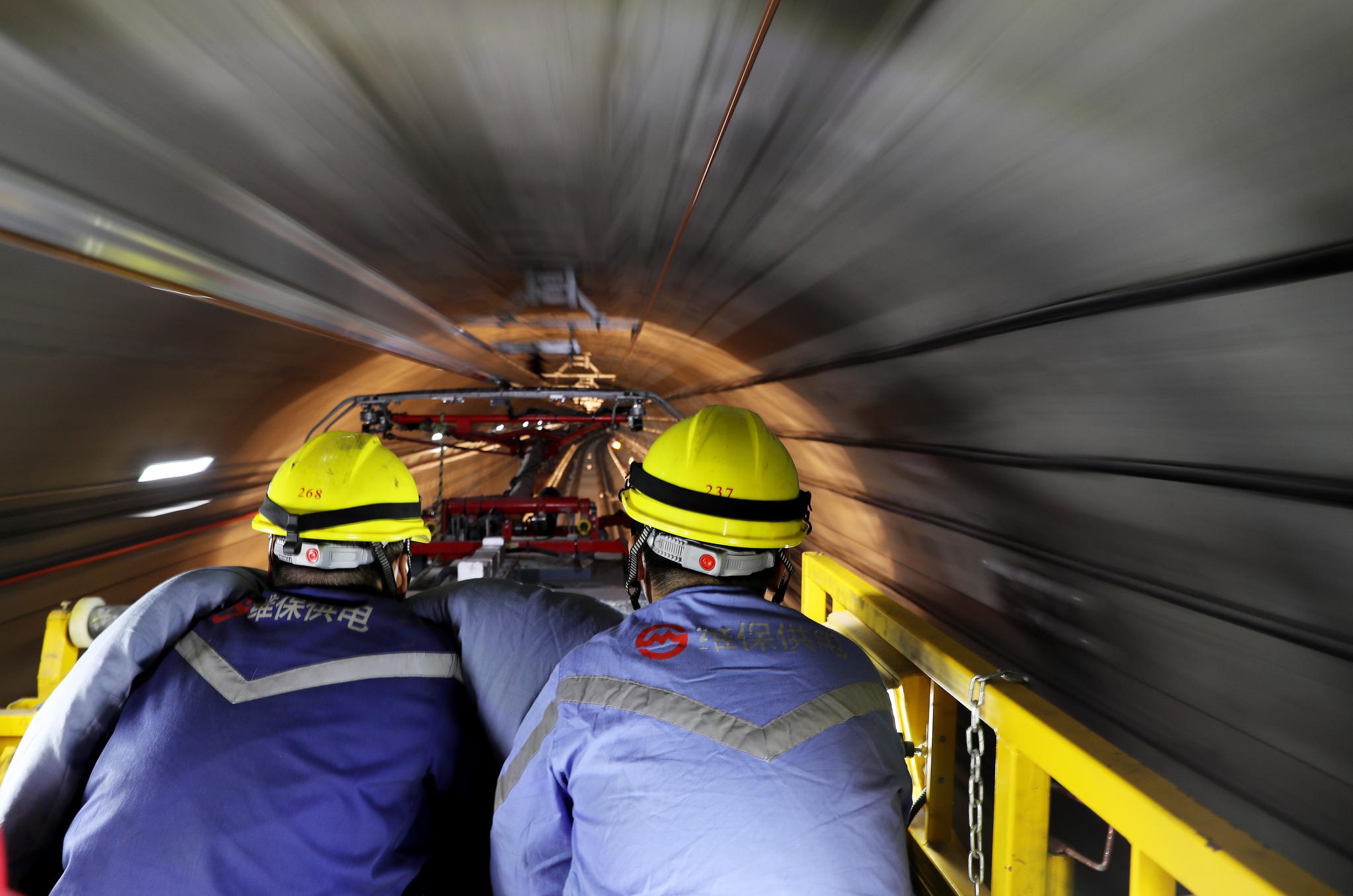 4月26日,来自中铁四局的技工在隧道内为冷滑作业车手动扳道岔.