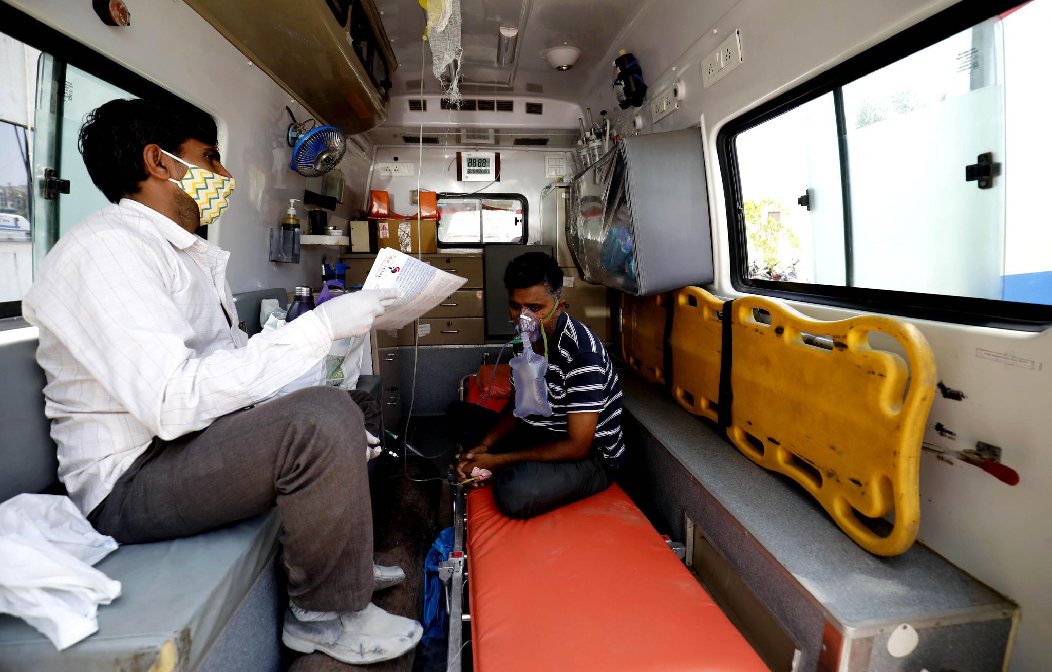 在印度城市艾哈迈达巴德一家医院内,由于没有床位,新冠病人在救护车上