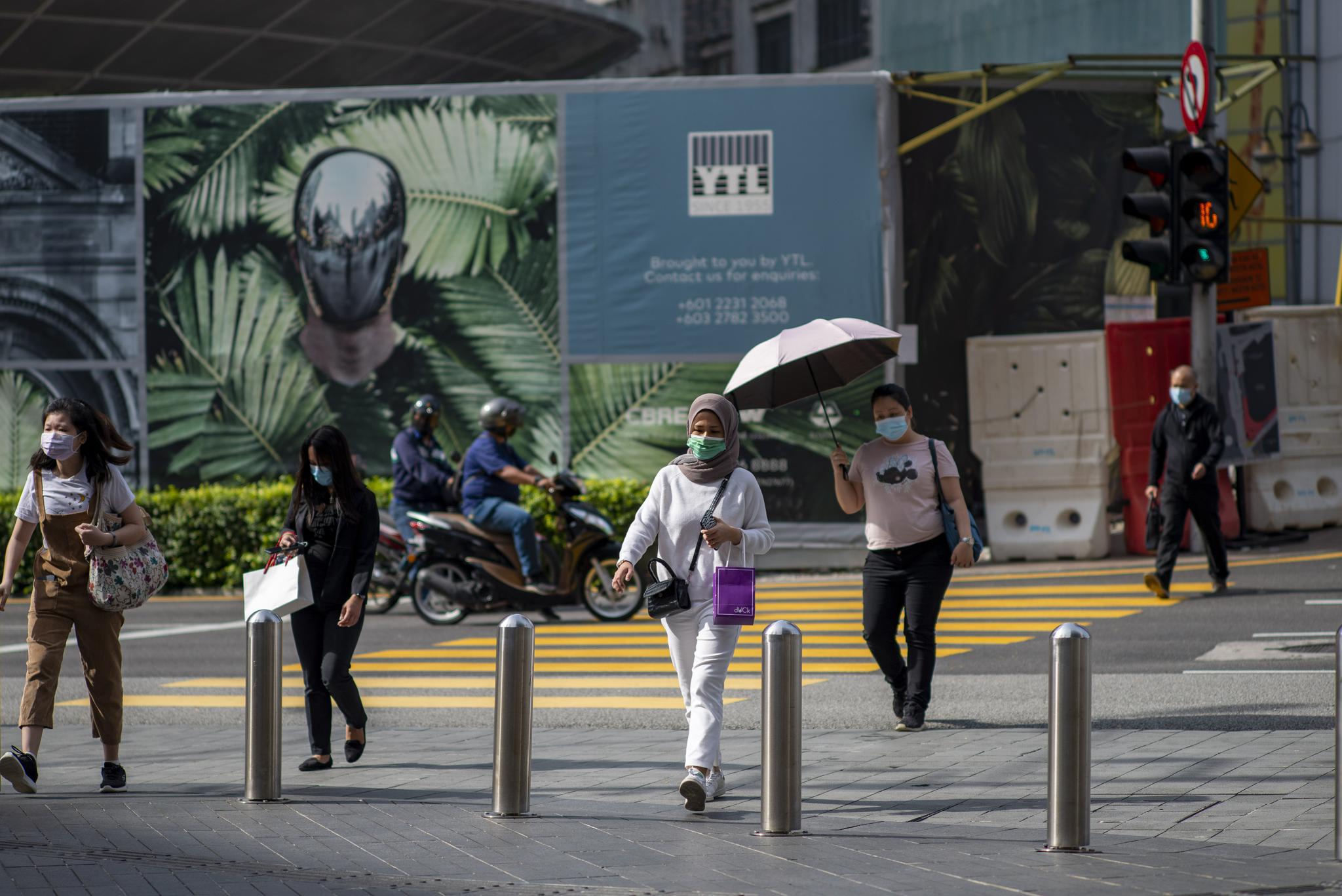 5月7日,人们戴着口罩走在马来西亚吉隆坡街头.