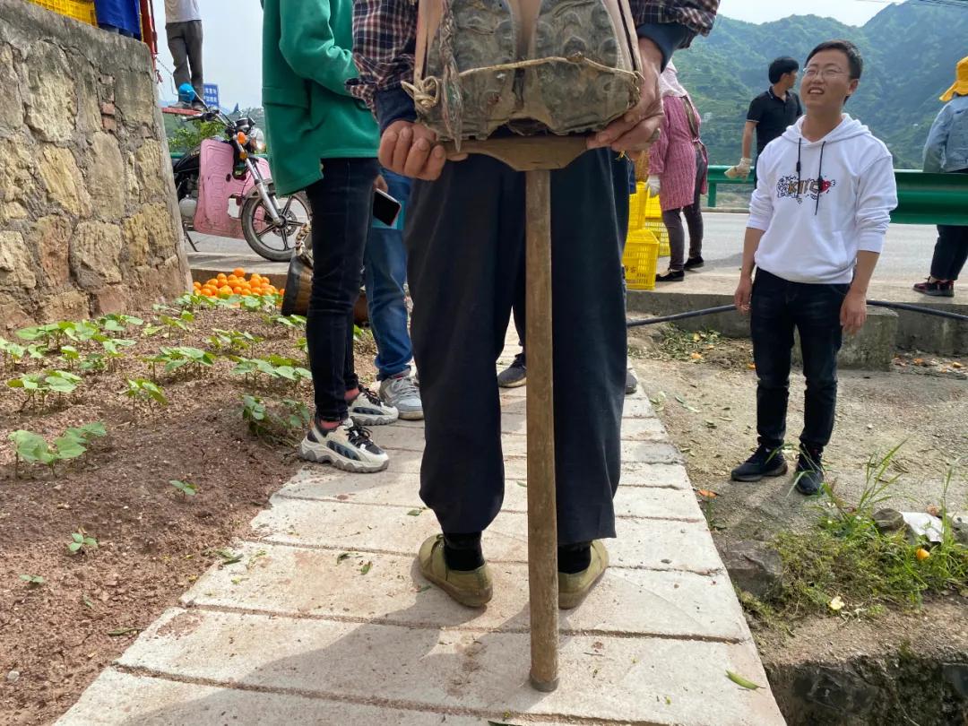 走累了就把手里的"打杵子"撑在竹筐下,原地歇个两分钟继续走,背脚们把