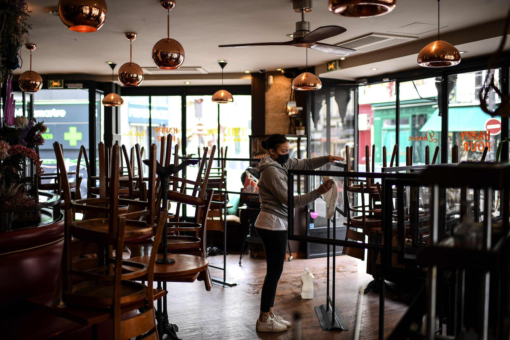 新华社/法新5月12日,法国巴黎一家酒吧的工作人员为重新营业做准备.