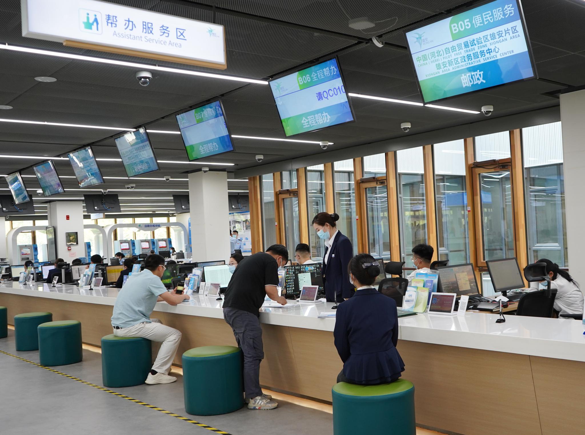 5月12日,在河北雄安新区政务服务中心服务台,居民进行人脸识别并取号.