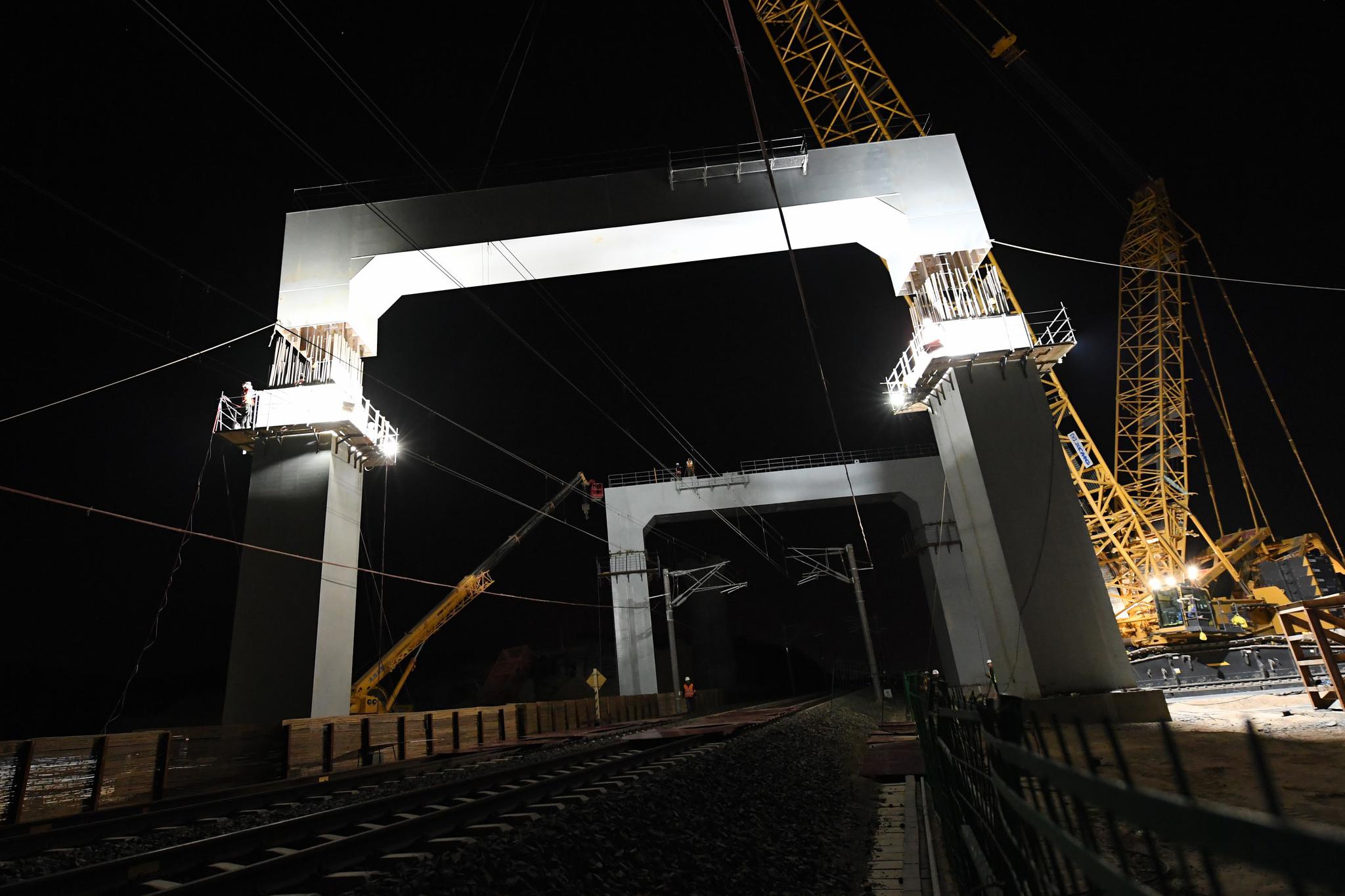 中兰客专甘肃段跨既有线钢横梁吊装施工现场,既有的中川城际铁路从