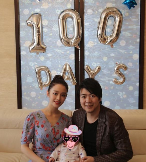 吉娜坐在中间,他的儿子在他的怀里,她的岳母和母亲都站在他的身后