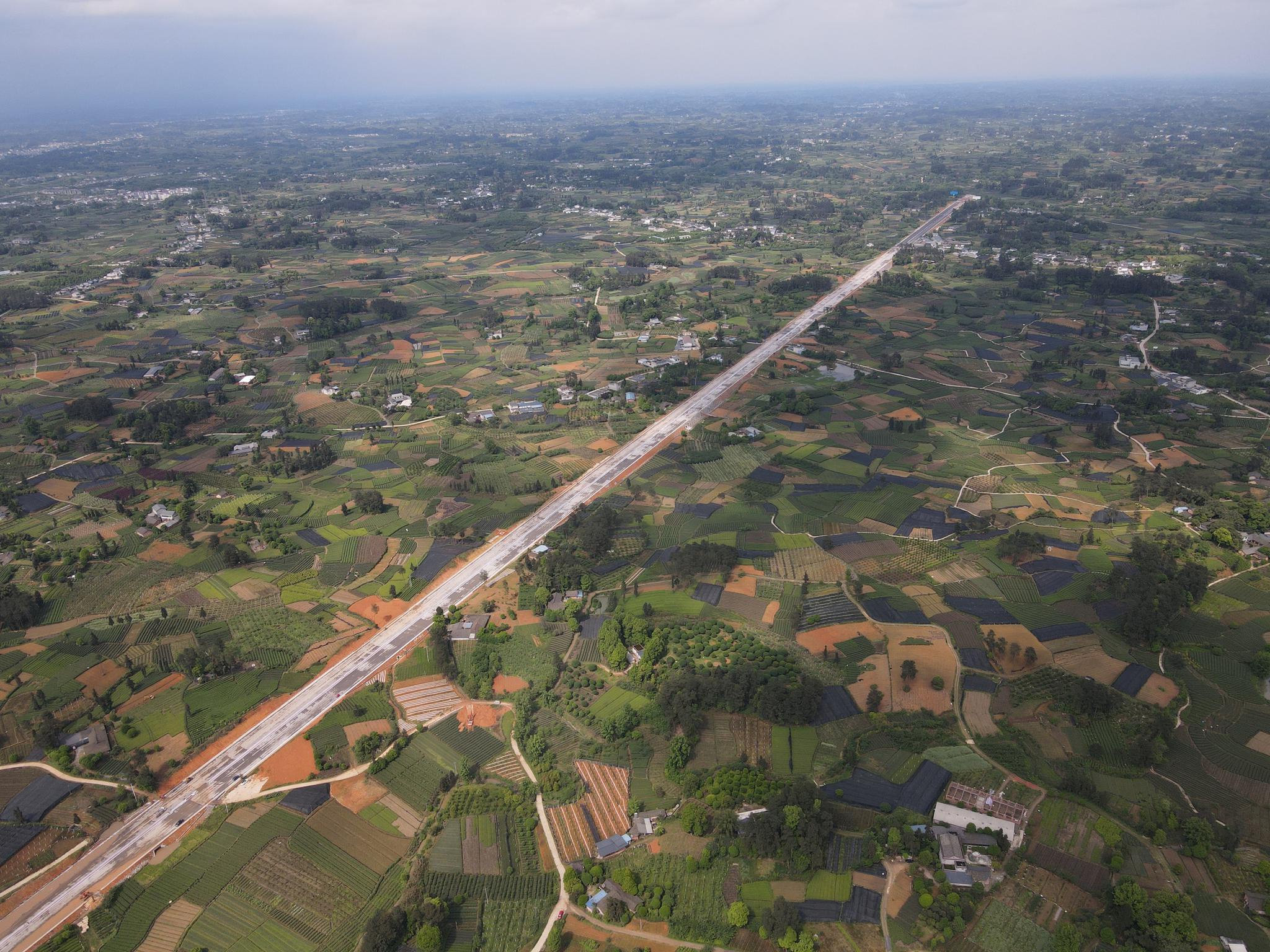 正在建设的成雅快速路(雅安段)穿过特色农业产业区(受访者供图)