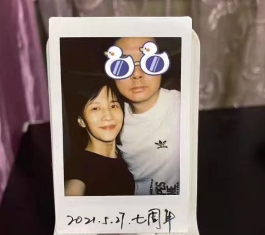 在照片中,papi酱手持着手机,对着镜头微笑着,依偎在丈夫老胡的胸前.