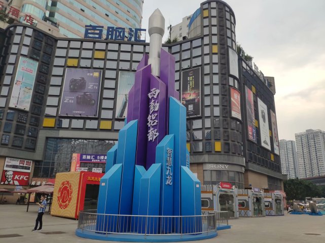 造型最吸引行人的眼球,站在石桥铺车站东望,火箭造型雕塑与远处的彩电