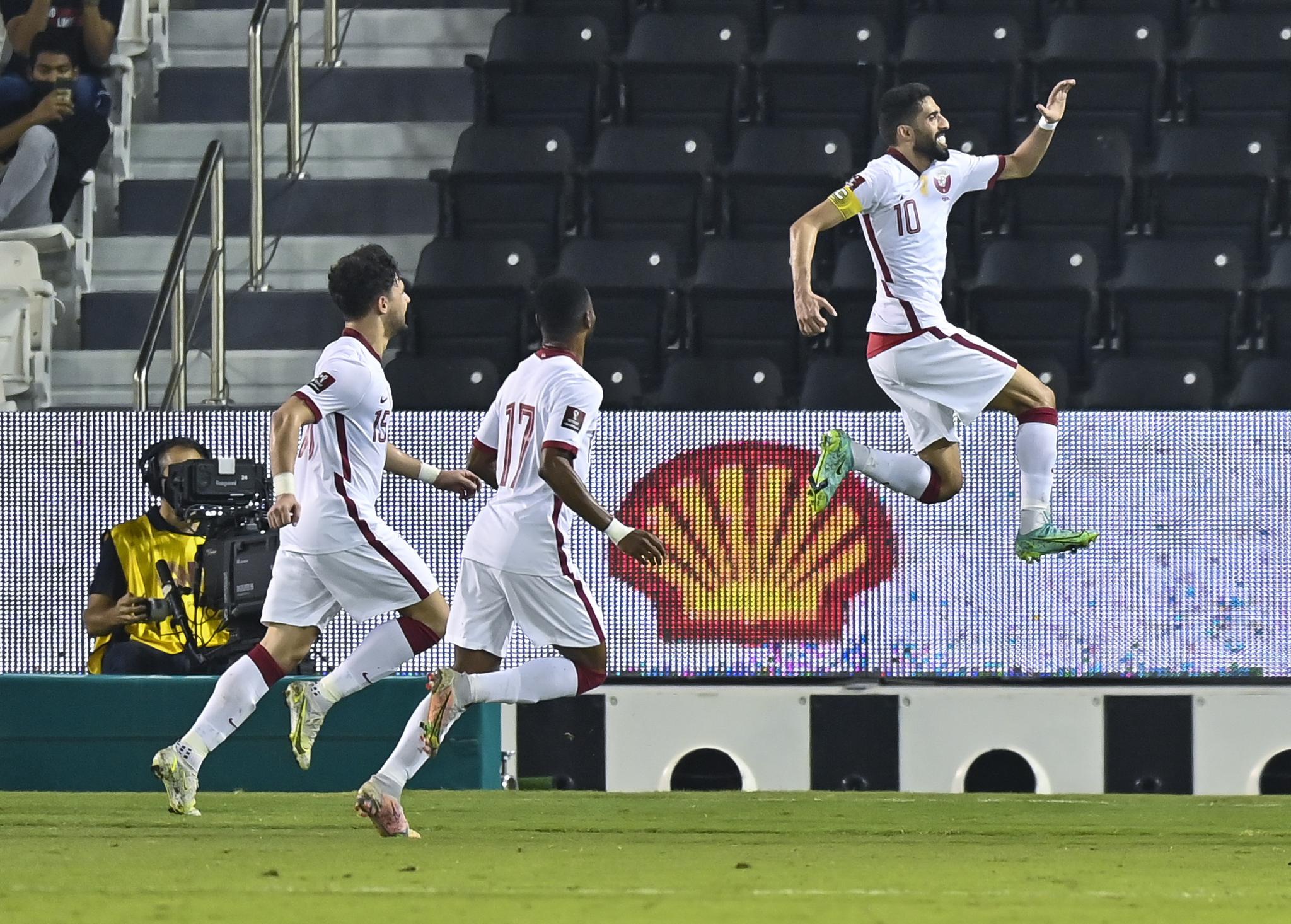 摄)6月7日,卡塔尔队球员莫埃兹·阿里(左)与阿曼队球员萨阿迪拼抢