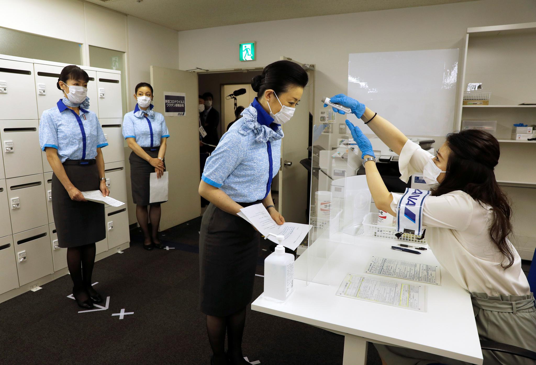 6月13日,日本全日空航空公司空乘人员在东京羽田机场接种新冠疫苗前