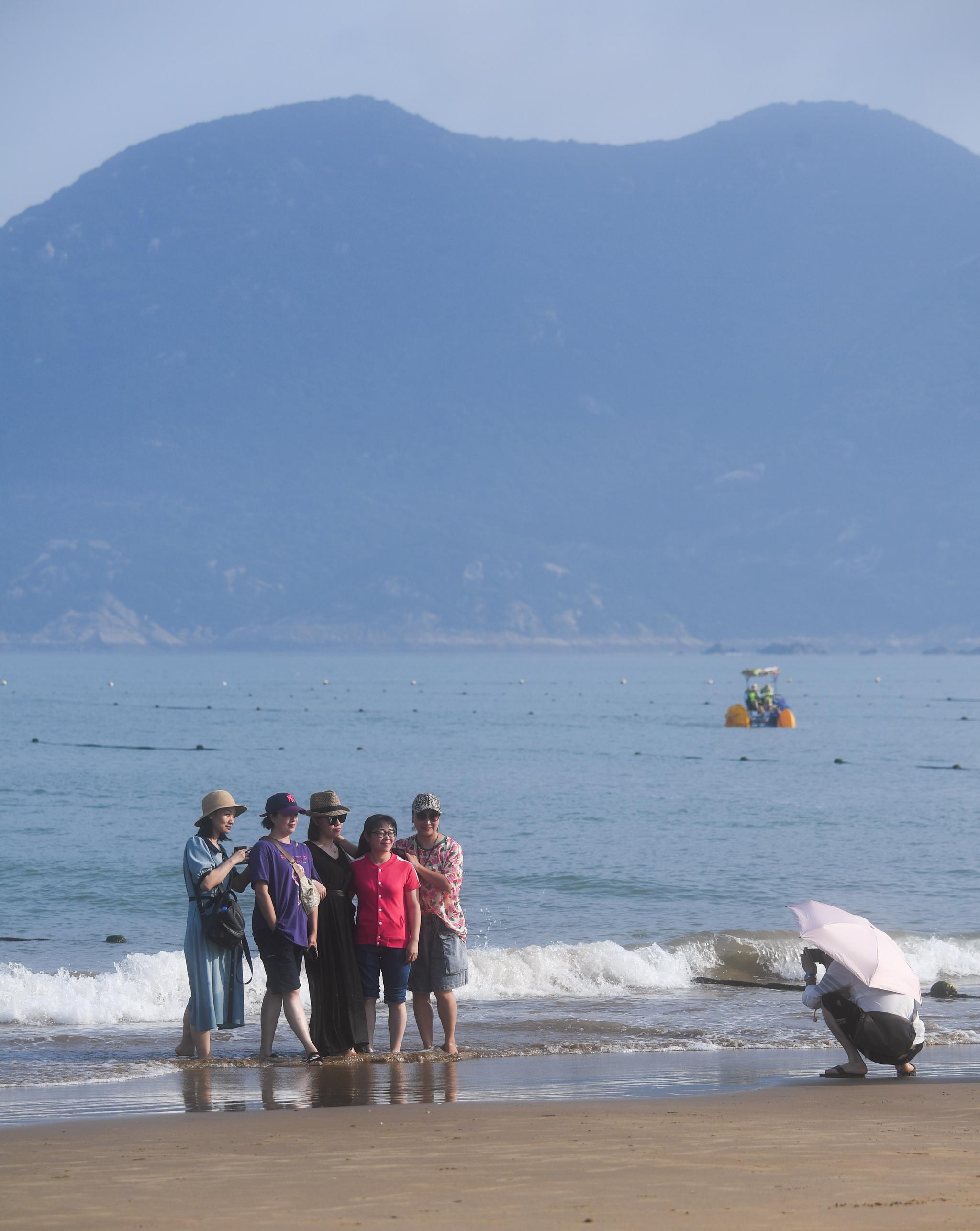 6月24日,游客在浙江省舟山市朱家尖南沙景区的沙滩上游玩(无人机