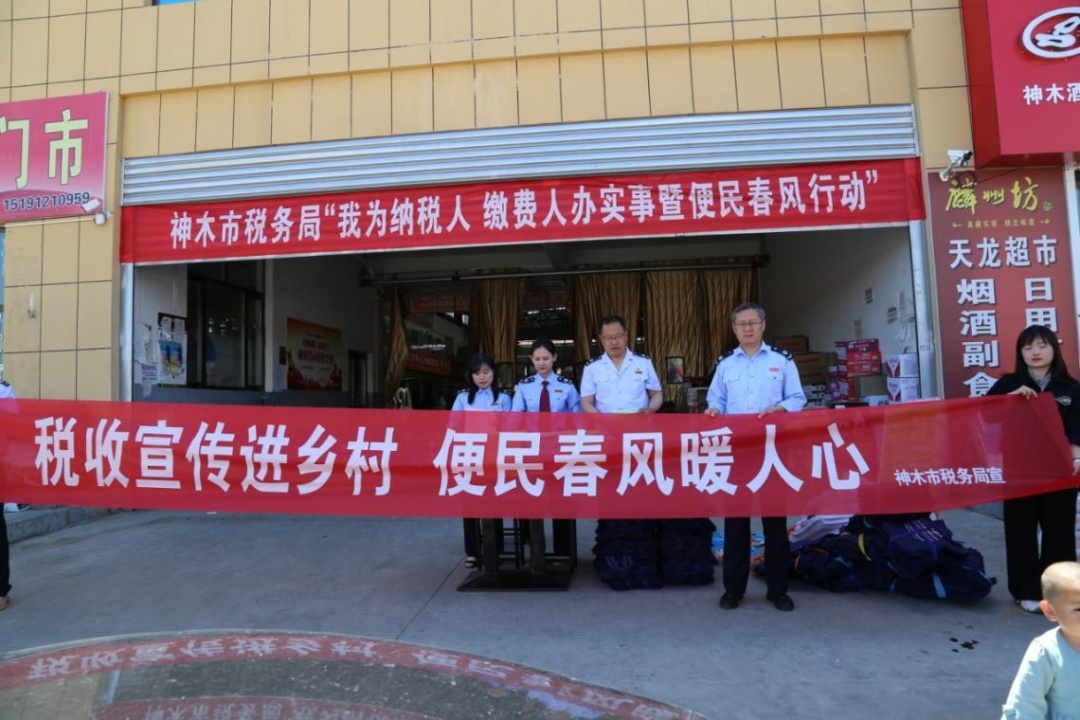 在乡镇集市繁华地段,街道悬挂税收宣传横幅标语,并设置现场服务点