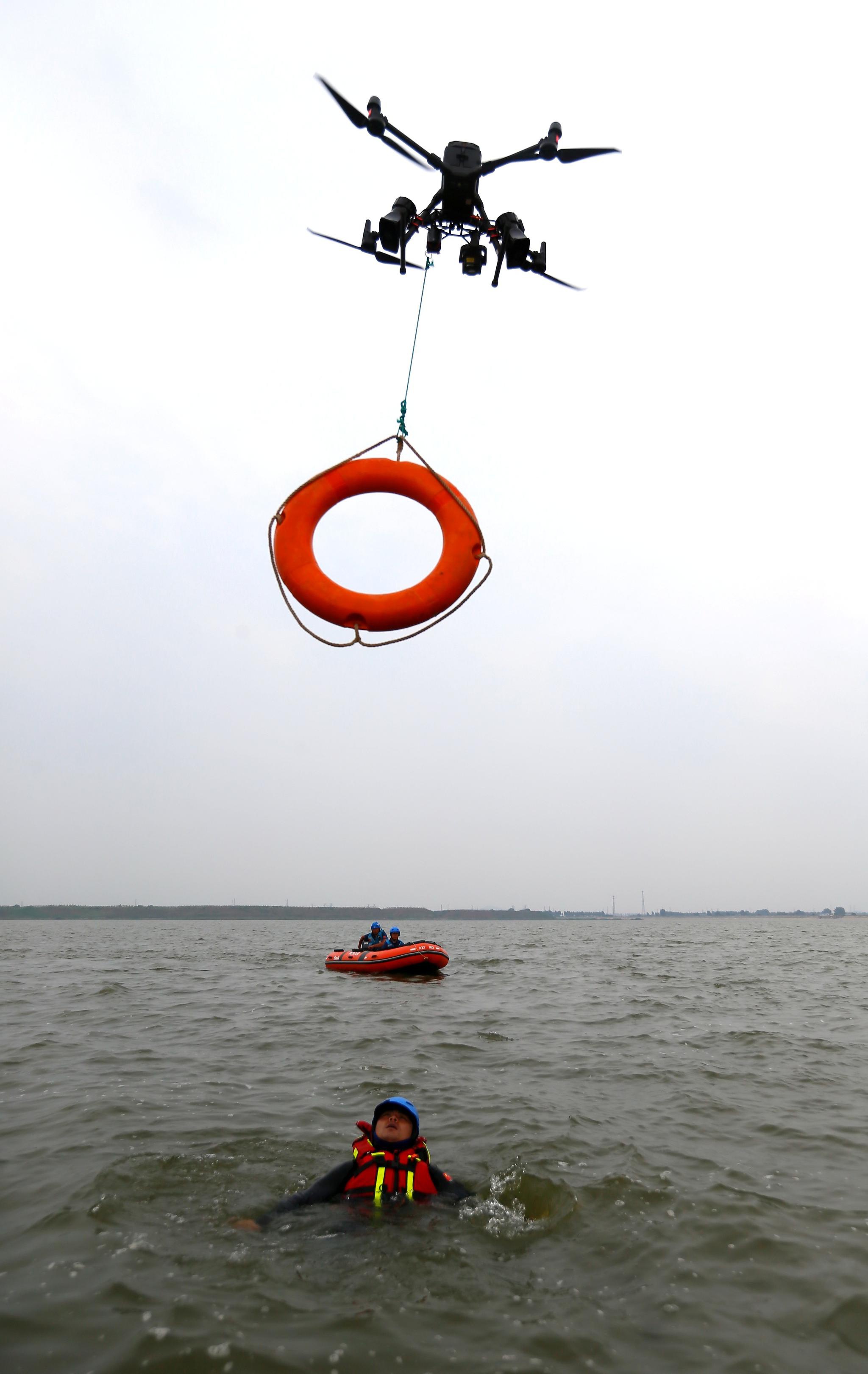6月25日,参加防汛救援综合实战演练人员在进行无人机抛救生圈救 
