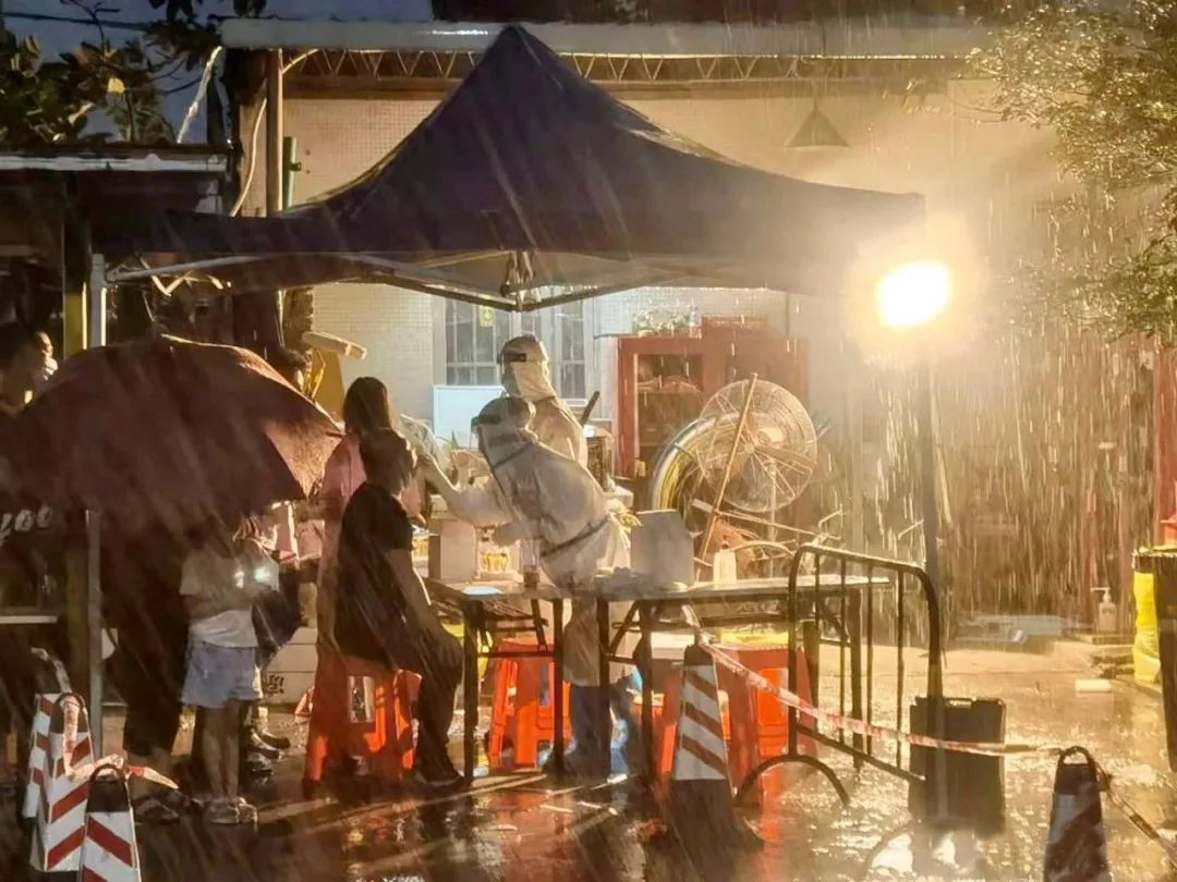 △ 医护人员深夜在暴雨中为市民做核酸检测。