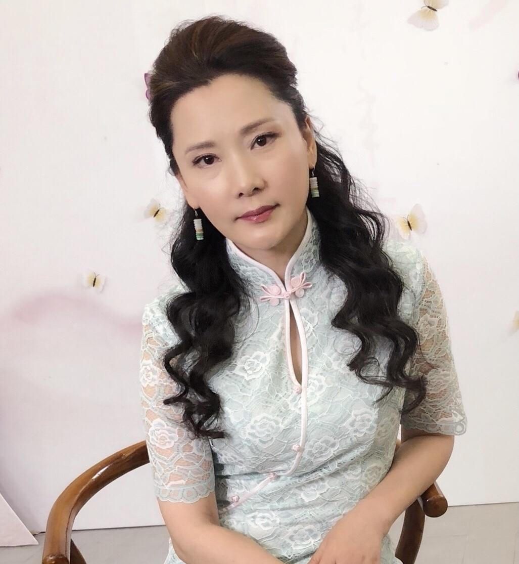 58岁的何赛飞一点不显老,穿玫红色改良旗袍温婉端庄,尽显东方美