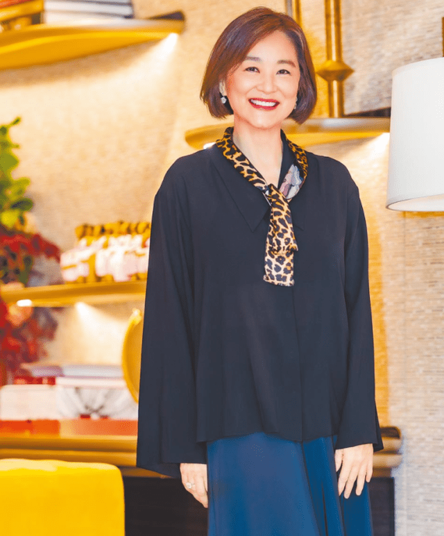 照片中,林青霞一头利落的短发,身穿黑色宽松上衣搭配蓝色长裙,脖子上