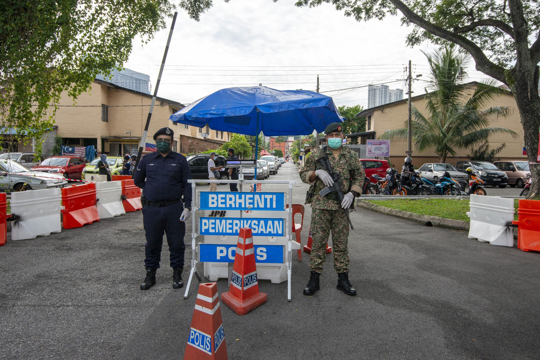7月3日,警察和士兵在马来西亚吉隆坡一处实施"加强行动管制令"的地区