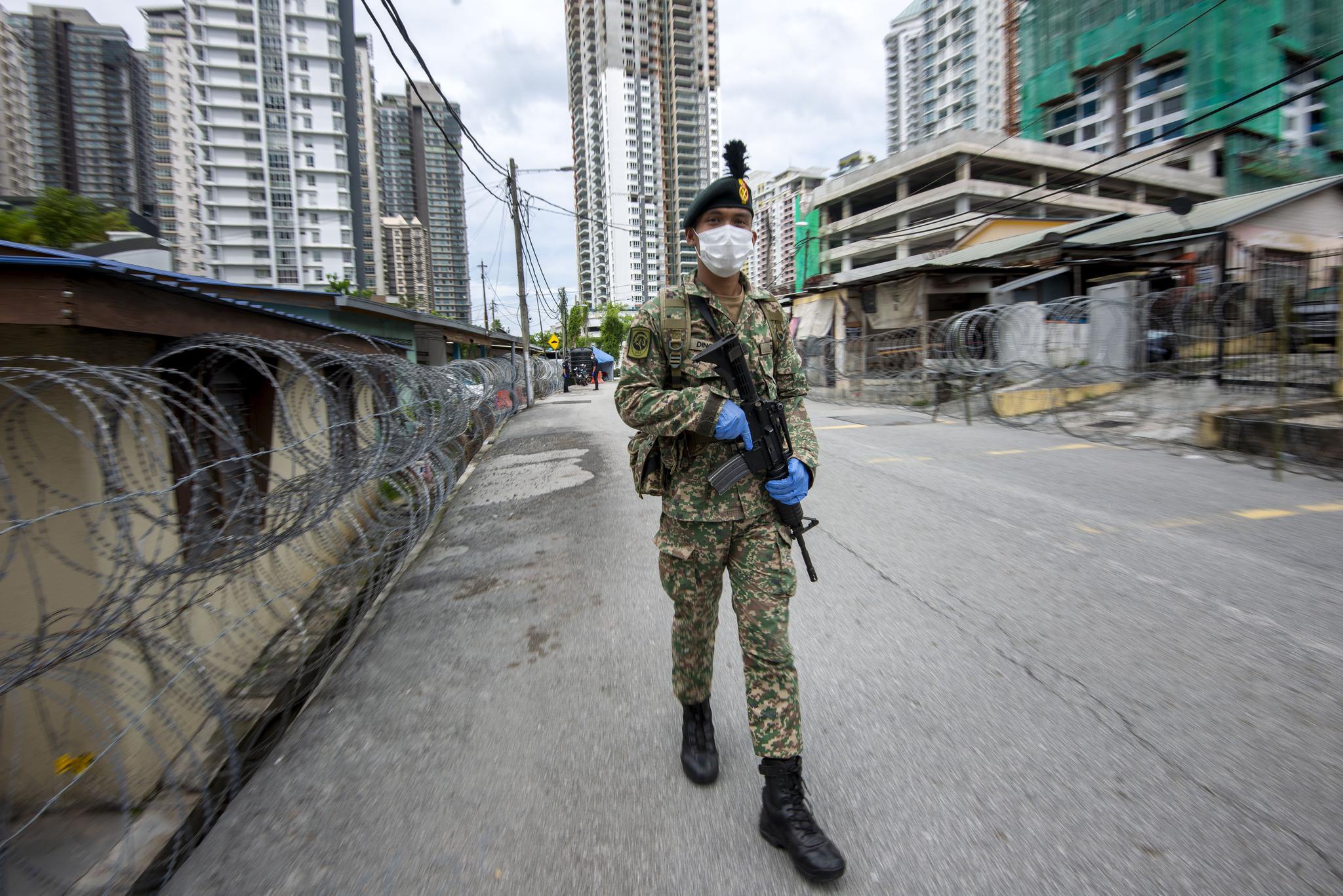 7月3日,士兵在马来西亚吉隆坡一处实施"加强行动管制令"的地区执勤.