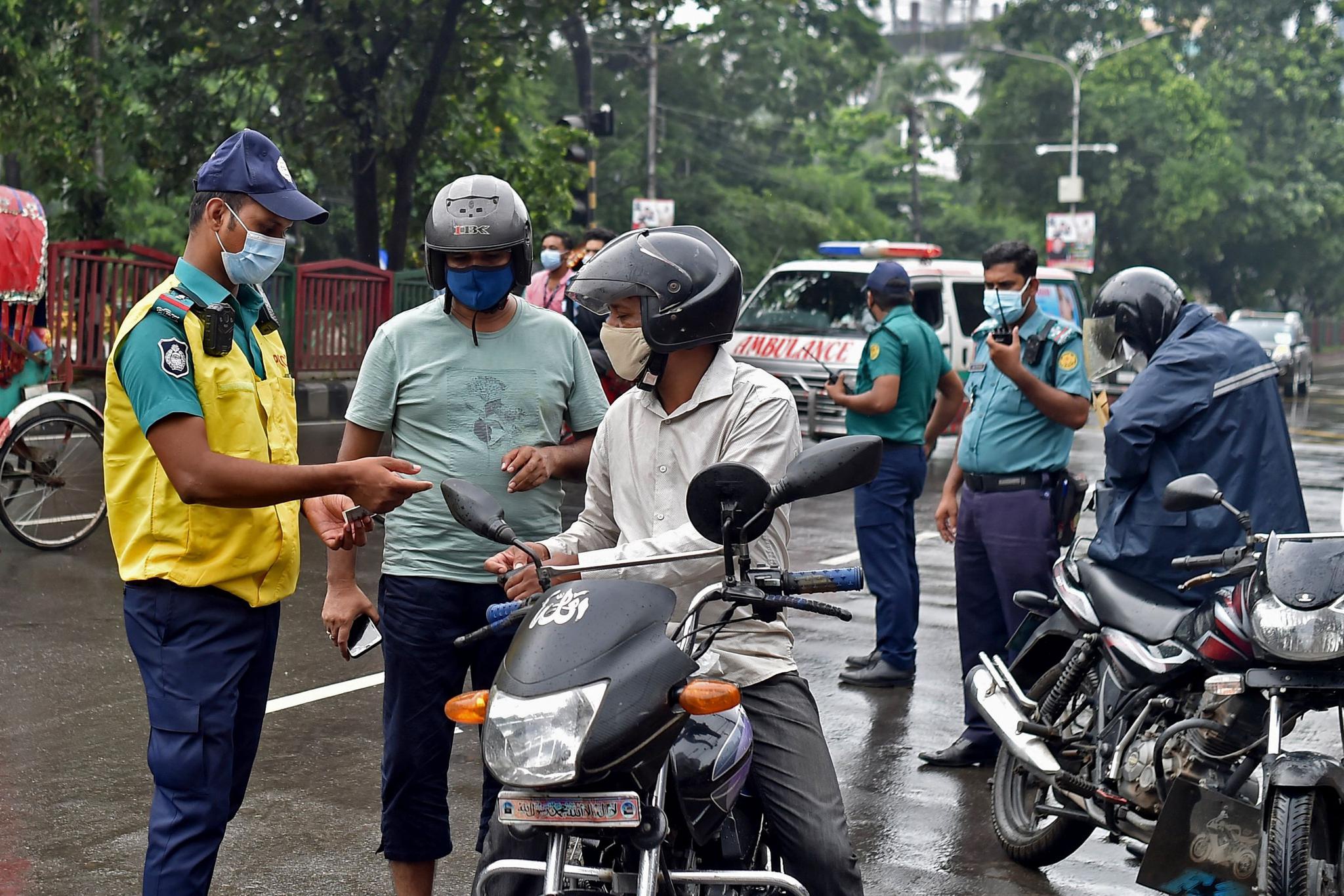 7月4日,警察在孟加拉国达卡街头设卡检查出行人员的身份证件.