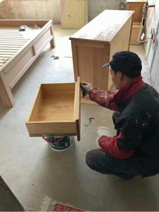 木工师傅现场做的实木家具,油漆师傅正在里外涂刷木蜡油