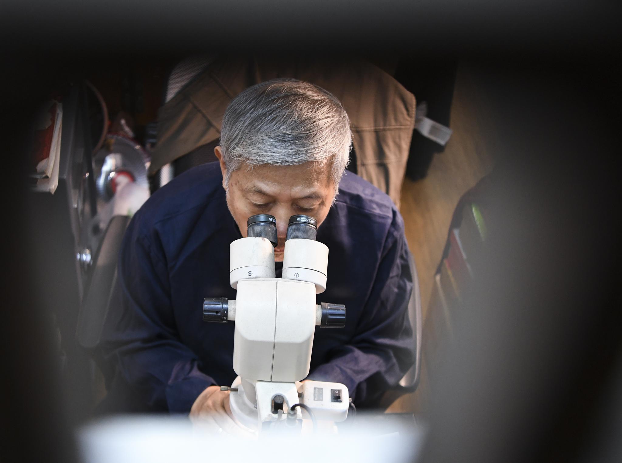 7月12日,潘启慧在整理自己的微刻作品.新华社记者王全超摄