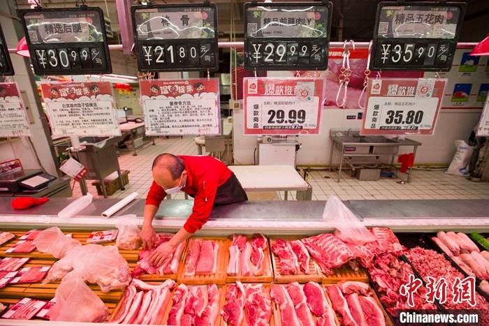 资料图：一超市内，工作人员在整理待售猪肉。 中新社记者 张云 摄