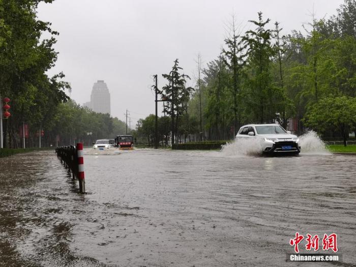  7月20日，河南郑州，车辆从积水路段通过。近日，郑州连遭暴雨袭击，持续强降雨导致部分街头积水严重。 中新社记者 李贵刚 摄