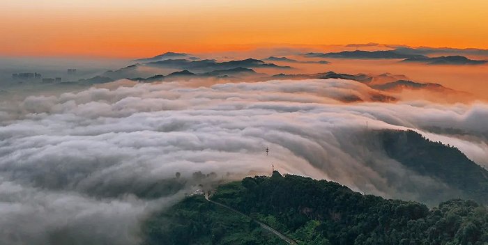 旭日东升，霞光浸染天际，龙泉山间云瀑奔涌。图片来源：嘉楠 摄