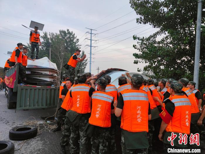 图为武警河南总队机动支队官兵正把船放入水中，准备乘船去堤坝处。杨大勇 摄