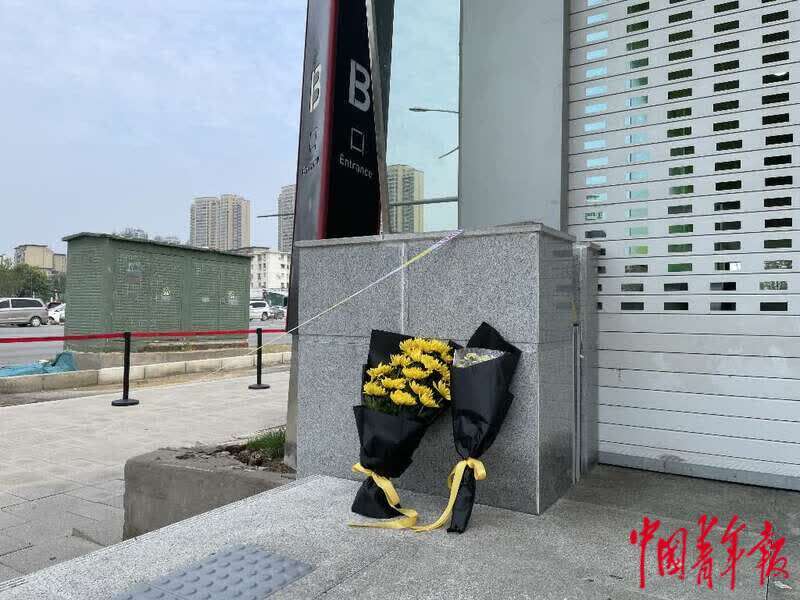 市民在郑州地铁5号线站口摆放菊花和糕点悼念遇难者