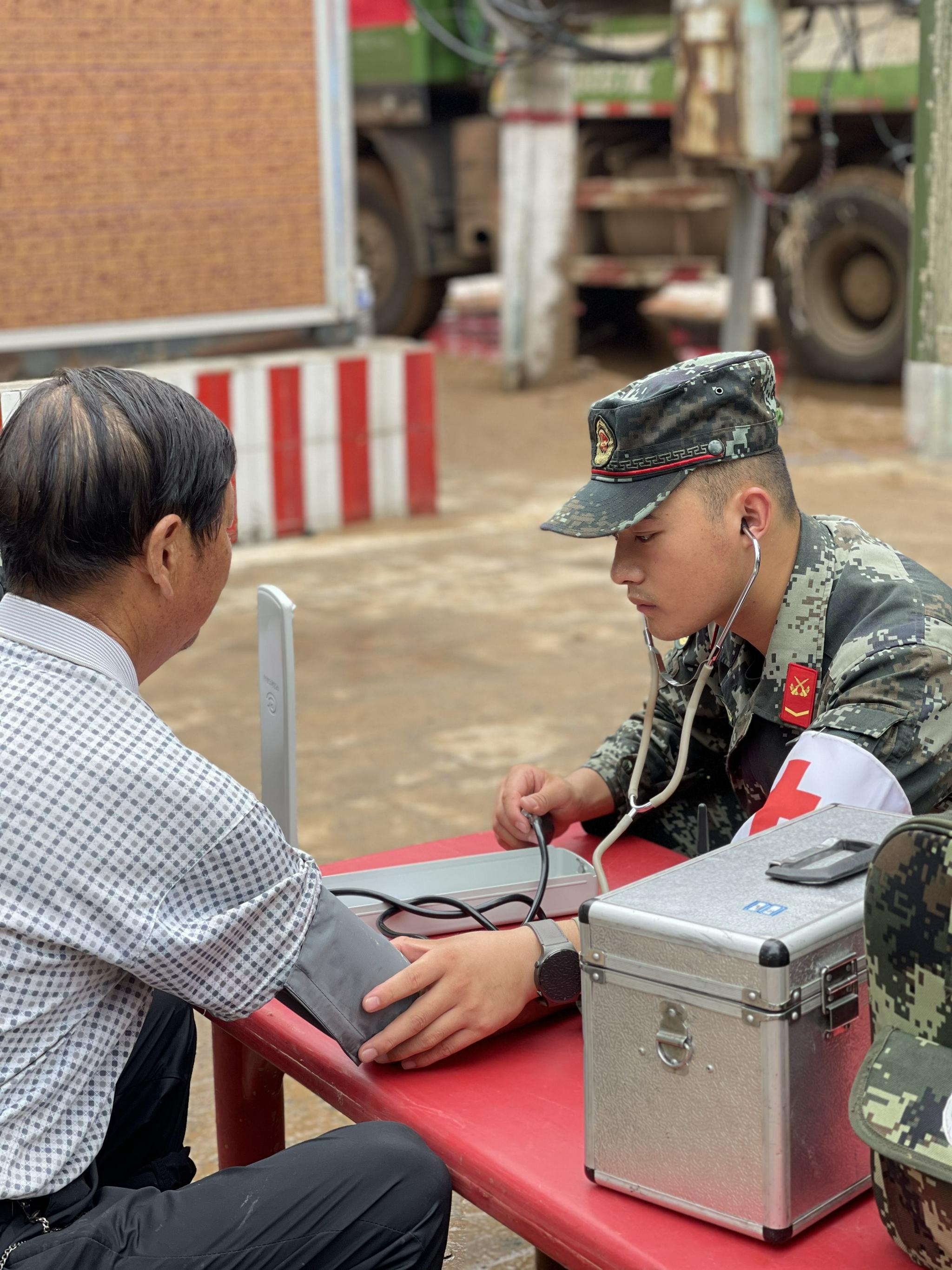 武警第一机动总队设立的医疗点，7月23日，一名军医正在给居民量血压。新京报记者 王瑞文 摄