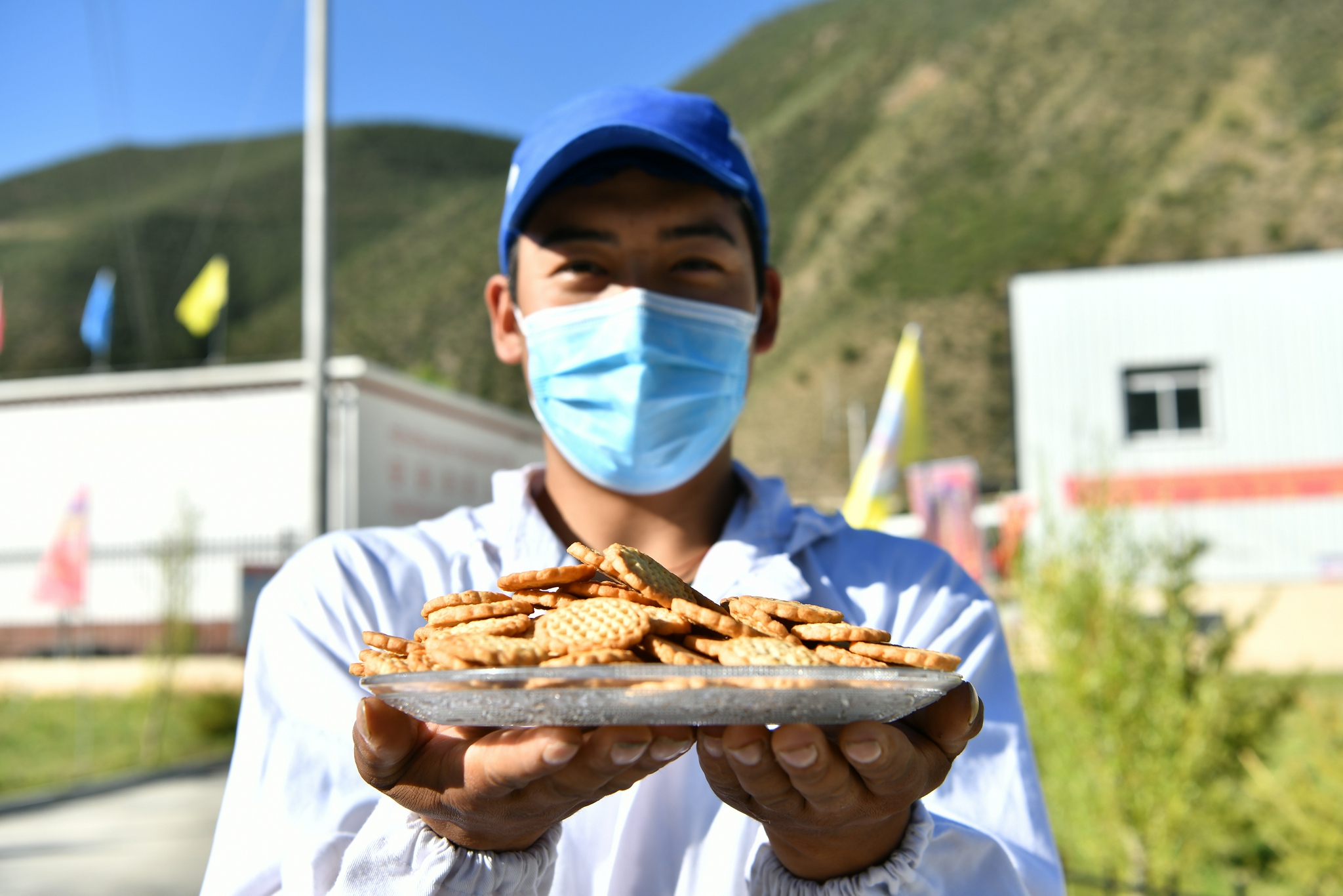 员工在洛宗特色产品开发公司的生产线上将烘炒好的青稞装袋(7月24日摄