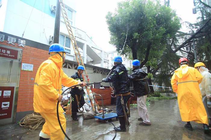 杨浦区延吉一村内一棵20年树龄的雪松压到架空线路导致电杆断裂，变压器受损，国网上海市北供电抢修人员奋力抢修受损设备，恢复周边供电。图片来源：国网上海电力