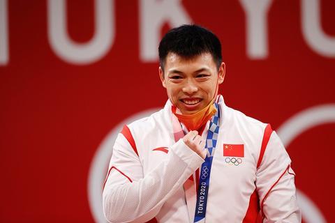当地时间7月25日，谌利军在颁奖仪式上摘下口罩。当日，中国选手谌利军在东京奥运会男子举重67公斤级项目中夺得金牌。 中新社记者 韩海丹 摄 图源：视觉中国