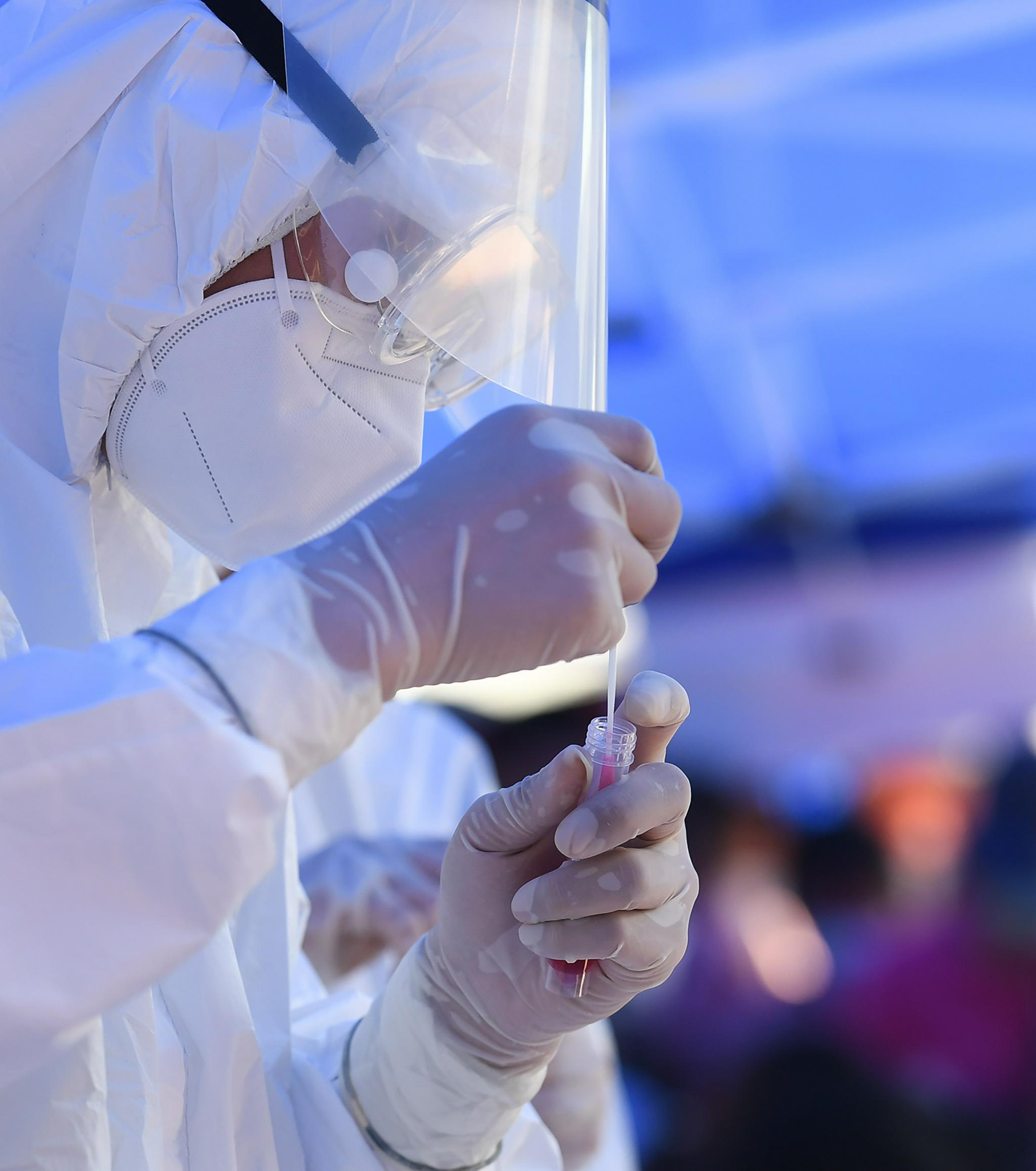 万科·金域蓝湾小区核酸检测点,江苏省中西医结合医院医生张勇在忙碌