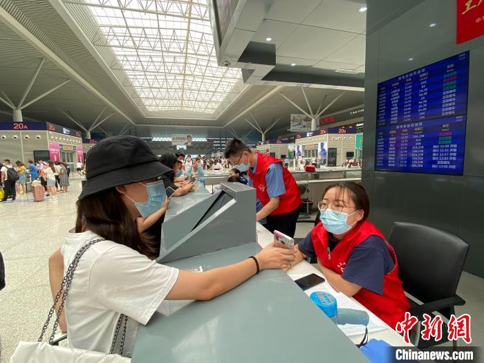 郑州东站服务台处，一名旅客正在询问相关列车车次等问题。郑州东站供图