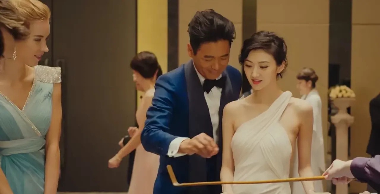 那时候的她,一袭白色晚礼服,一脸娇羞地问周润发"我想玩这个,但不知道