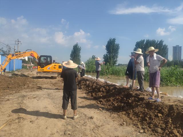 工人在贾鲁河边筑起土堤坝。邢祺欣摄