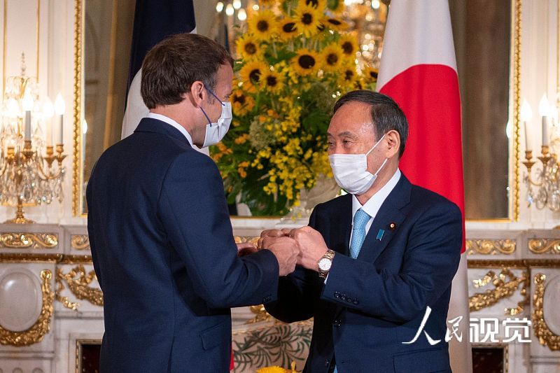 日本首相菅义伟在东京会见法国总统马克龙。图片来源：视觉中国