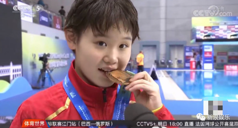 然后我们陈家齐就奶奶地看着镜头,按照记者所说的,轻轻咬了一下奖牌