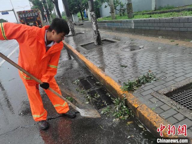 图为北京排水集团防汛工作人员在南苑路清理雨水口。 北京排水集团供图